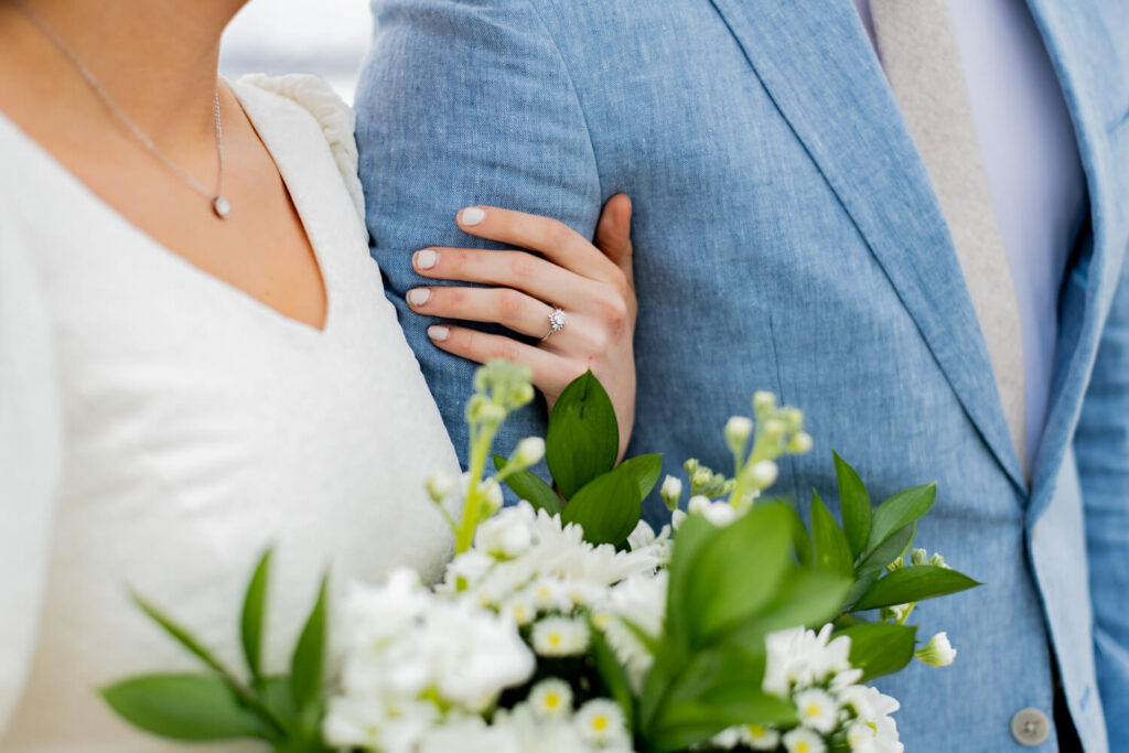 Bride holding onto groom's arm with ring in focus