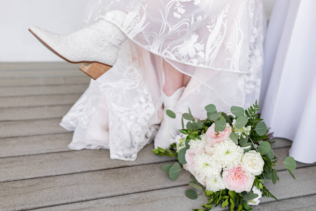 Closeup of the bride's boots and flowers on the ground