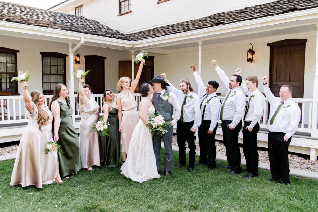 Bride and groom kissing while bridesmaids and groomsmen kiss