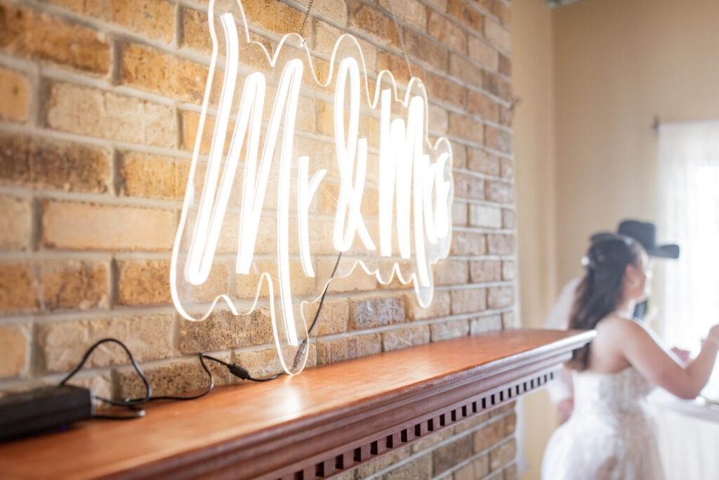 neon sign that says Mr & Mrs above a fireplace