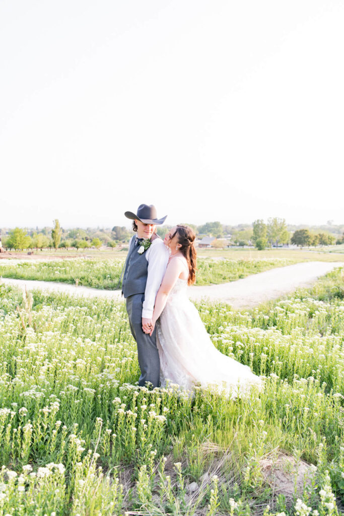 Bride and groom looking at each other in a field of wildflowers