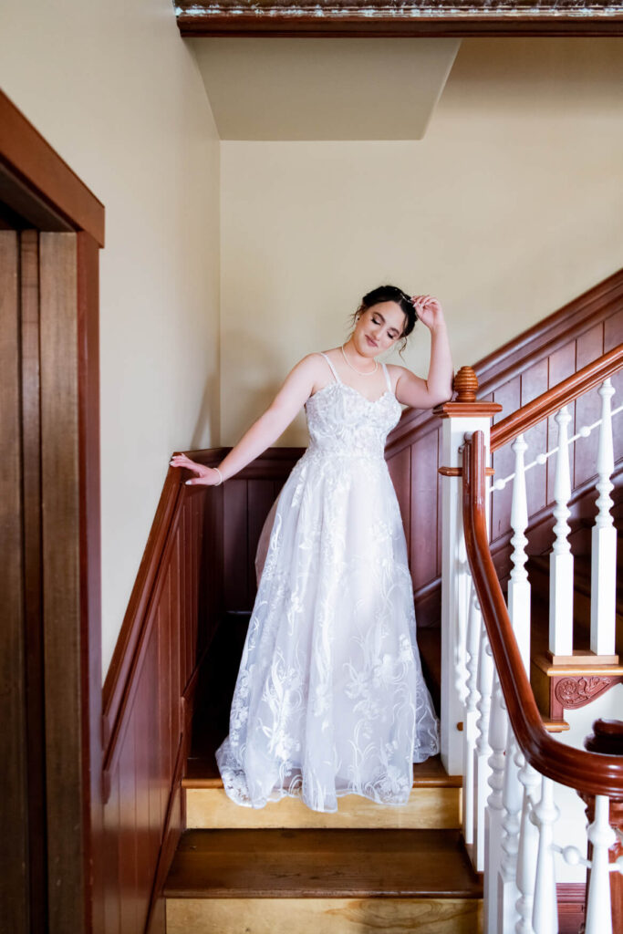 Bride standing on a staircase and leaning against the railing