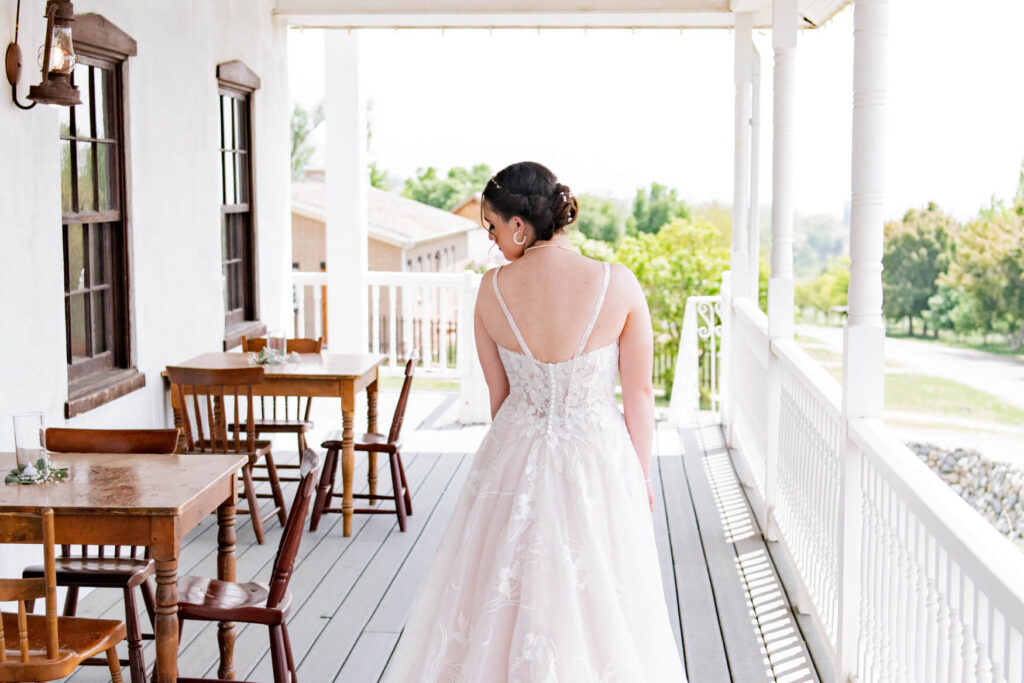 Bride looking down with her back to the camera on a porch