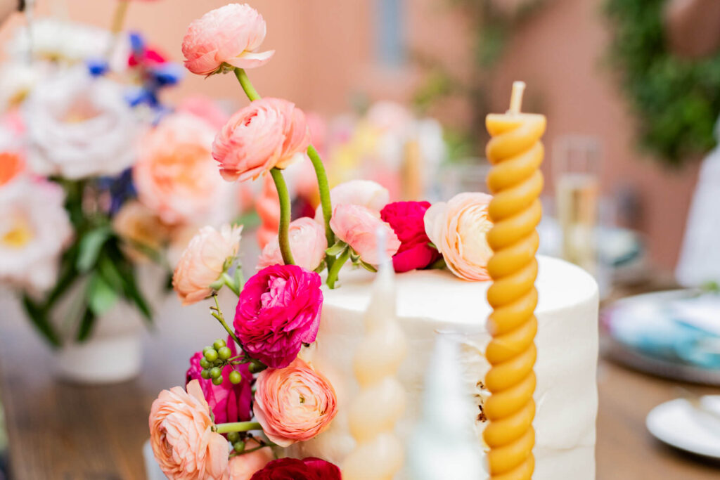 Flowers on a cake with candles around it.