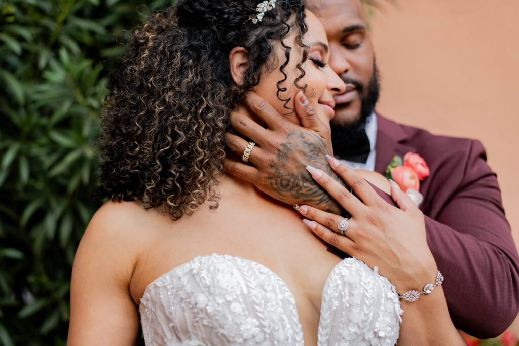 Groom's hand on his bride's face in a very close up picture