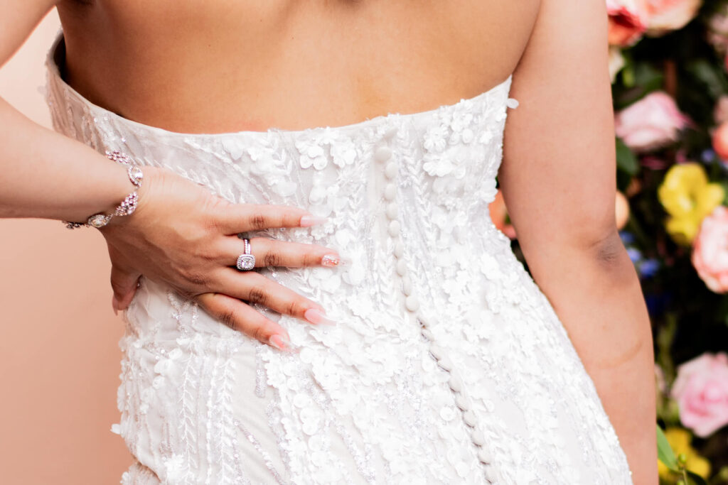 Bride's hand on her hip, very cropped in on her ring.