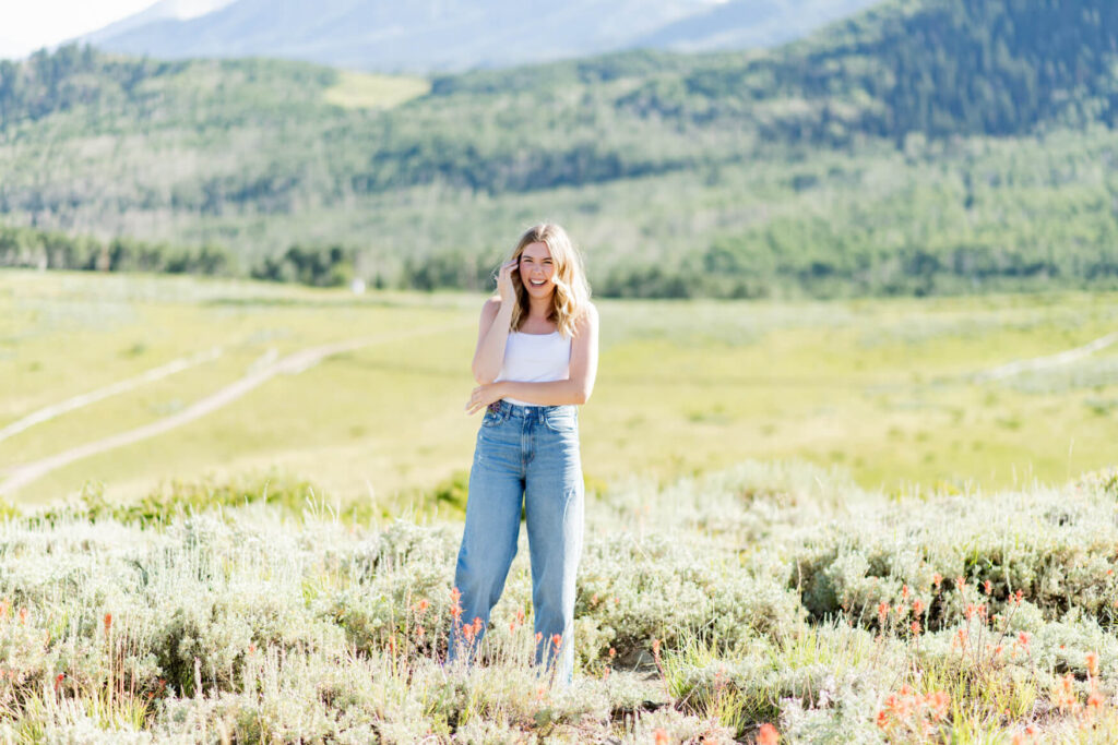 Girl standing in front of a large meadow laughing