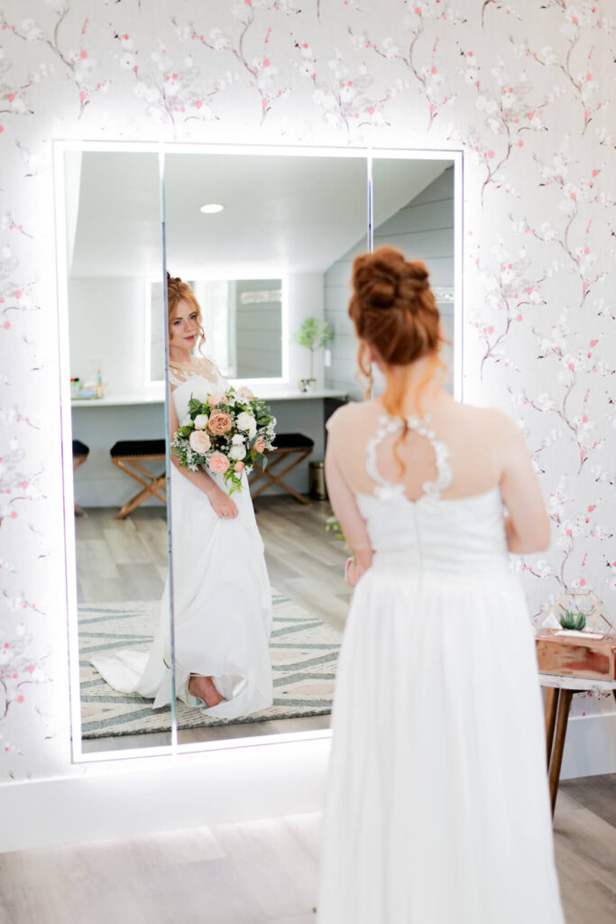 Bride looking at herself in a big mirror