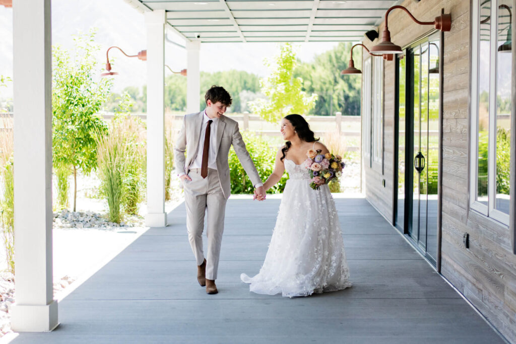 Bride and groom walking outside on the patio