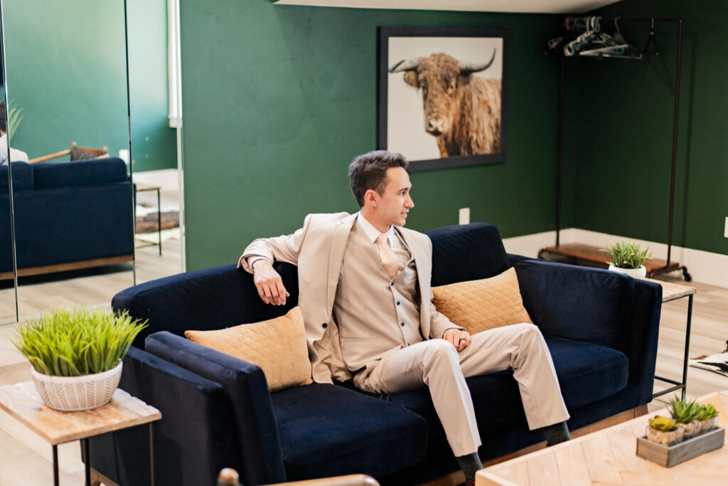 Groom relaxing on a couch in the grooms room