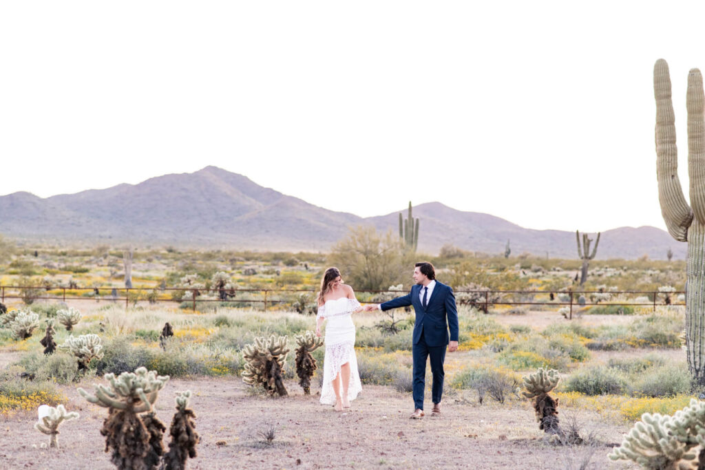 Bride and groom walking through the Arizona desert.