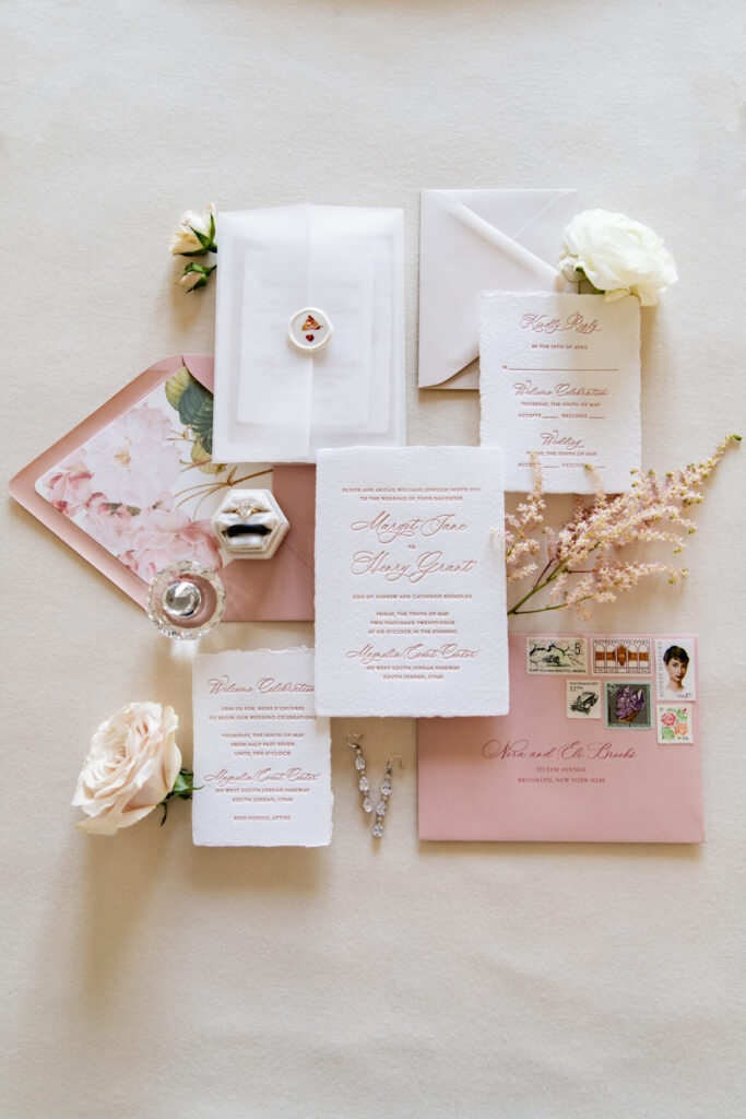 Flat lay with invitations, rings, flowers, envelopes, etc.
